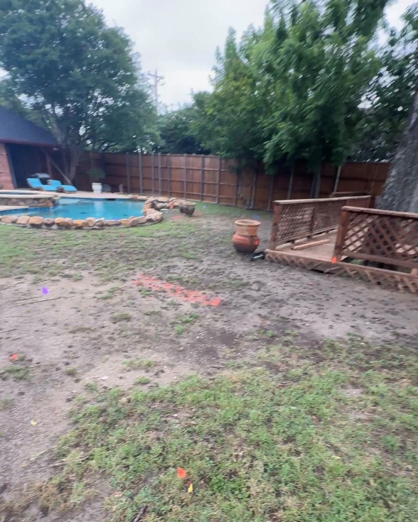 Backyard with patchy grass and bare soil before irrigation installation